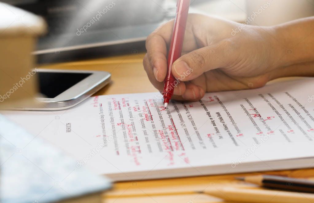 Pagine di un testo con segni di editing e penna rossa